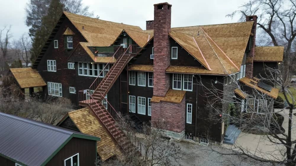 Cedar shingle roof rear elevation Rear elevation of a large home with a cedar shingle roof and brick chimneys
